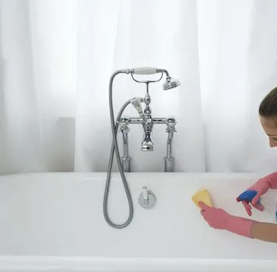Woman cleaning white tub