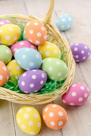 Easter basket with green grass filled with brightly colored polka dot Easter eggs