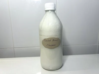 Bottle of DIY liquid toilet bowl cleaner on back of toilet