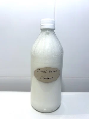 Bottle of homemade liquid toilet bowl cleaner on back of toilet