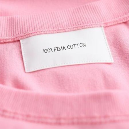 Picture of close up of 100% Pima cotton label on pink clothing
