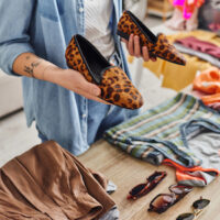 Woman inspecting shoes at a clothing swap