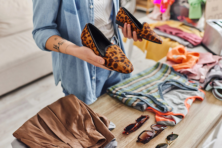 Woman inspecting shoes at a clothing swap